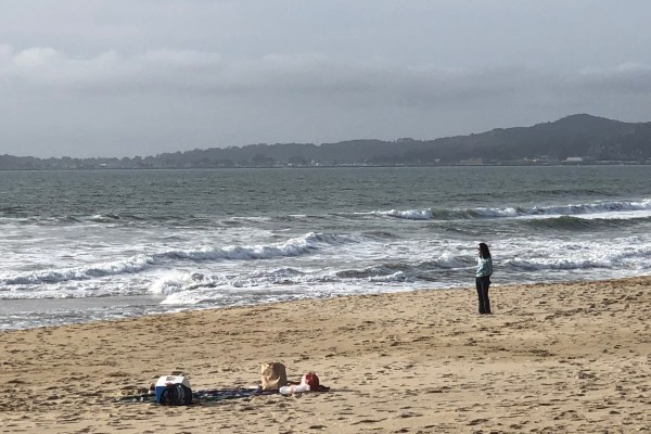 Panorama of the beach with the ocean and mountains in the backdrop.