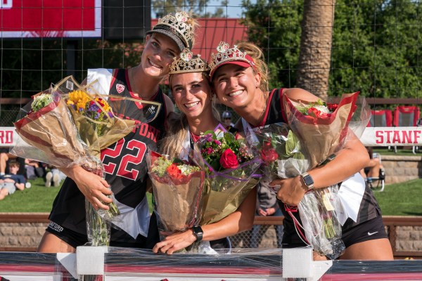 Charlie Ekstrom, Jordan McKinney and Maddie Dailey pose for a photo on Senior Night with their flowers.