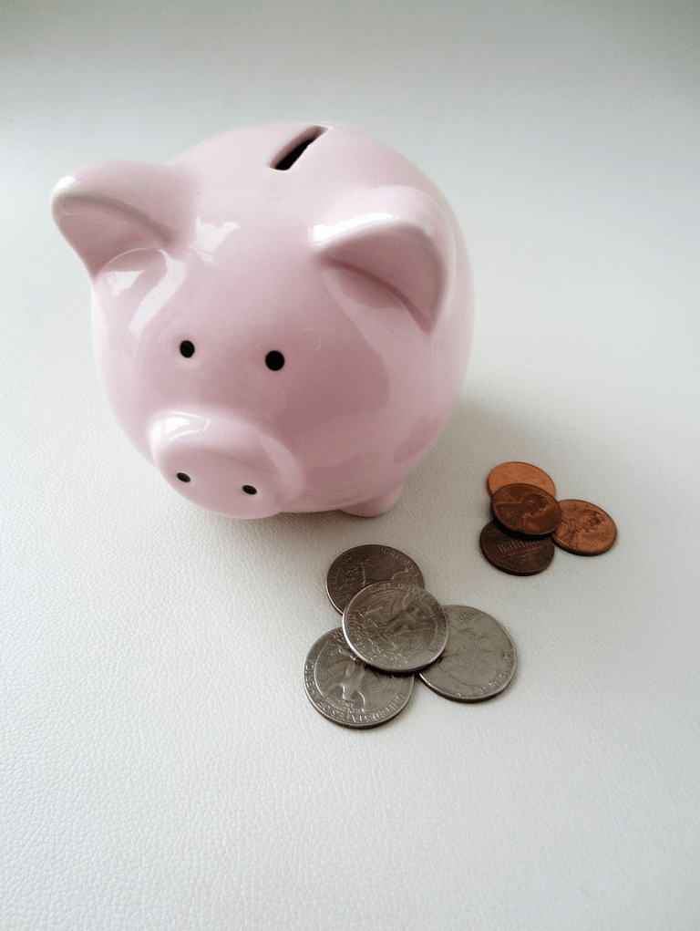 a piggy bank next to a pile of 4 quarters and a pile of 4 pennies