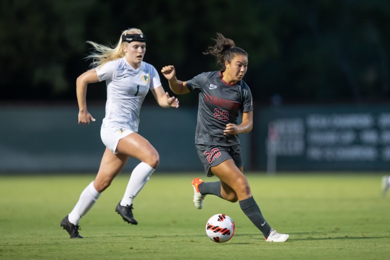 Stanford soccer player Andrea Kitahata dribbles the soccer ball past her defender