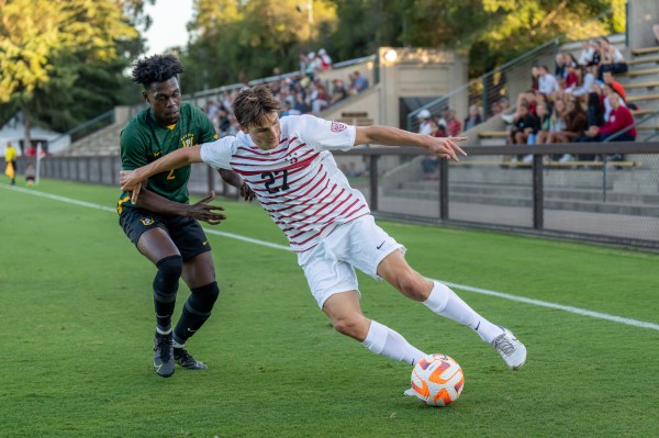 Stanford player wards off San Francisco defender.