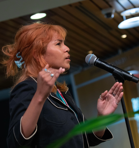 Winder speaking into a microphone on stage