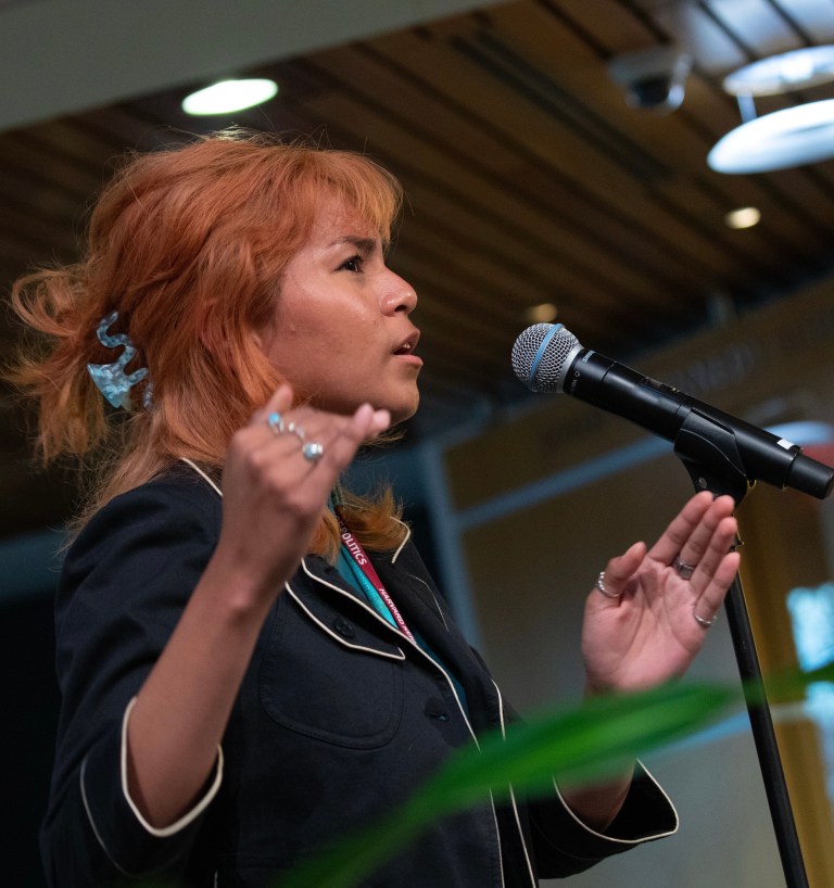 Winder speaking into a microphone on stage