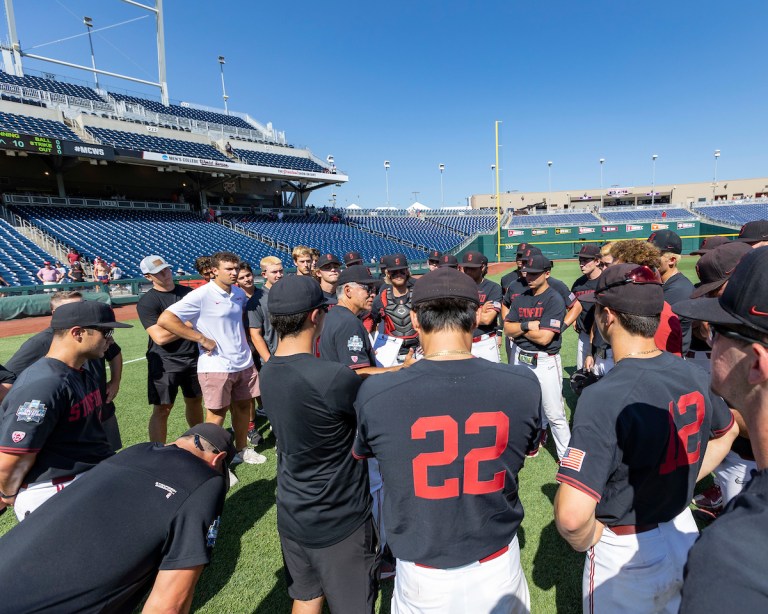 Stanford baseball huddles together on the field.