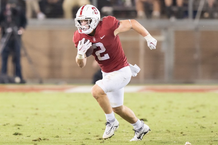 A football player runs while holding the football