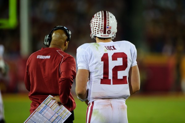 Quarterback stands next to his coach.