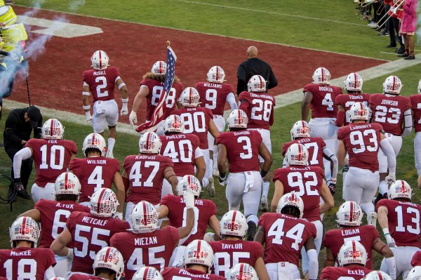 The Stanford football team runs onto the field