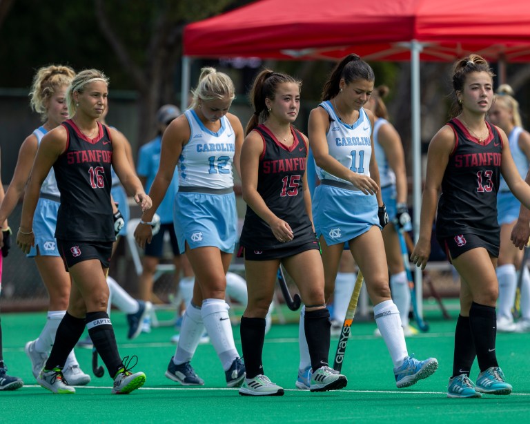 Field hockey players Molly Redgrove, Ella Ganocy and Bella Ganocy walk onto the field before a game.