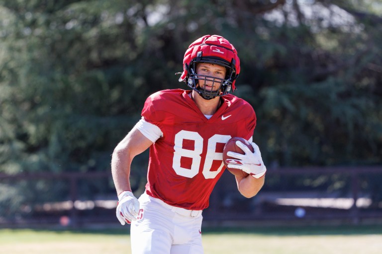 Football player looks at the camera while carrying the ball