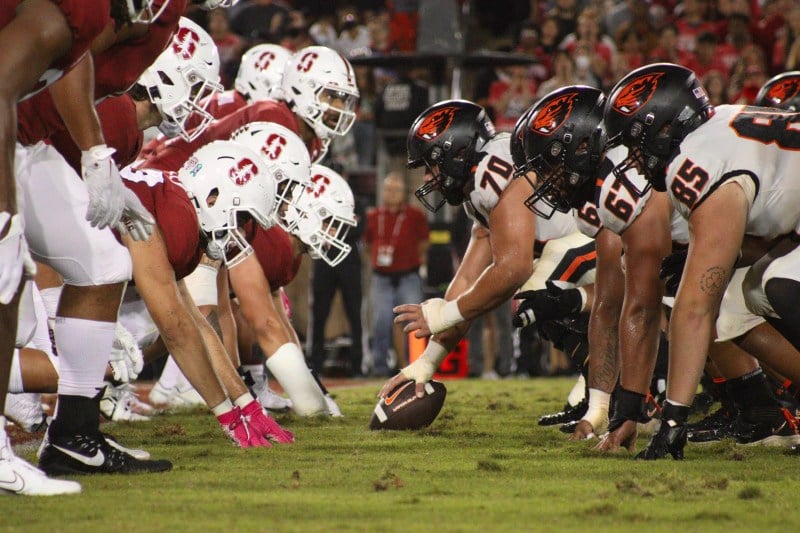 Two football teams take their position at the line of scrimmage