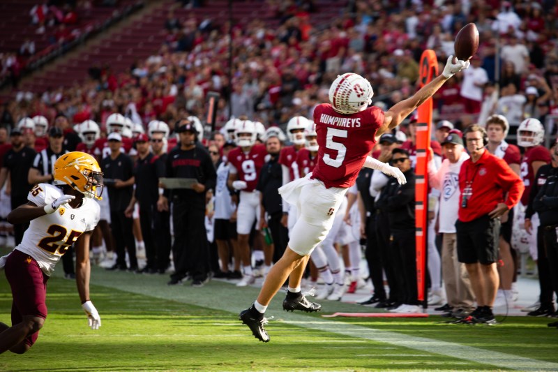 A player extends his arms out to try and catch the football