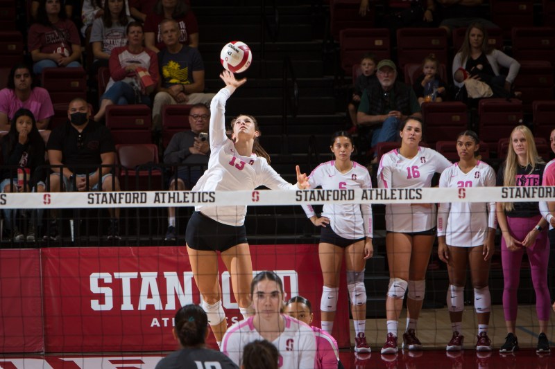 A volleyball player jumps to serve the ball