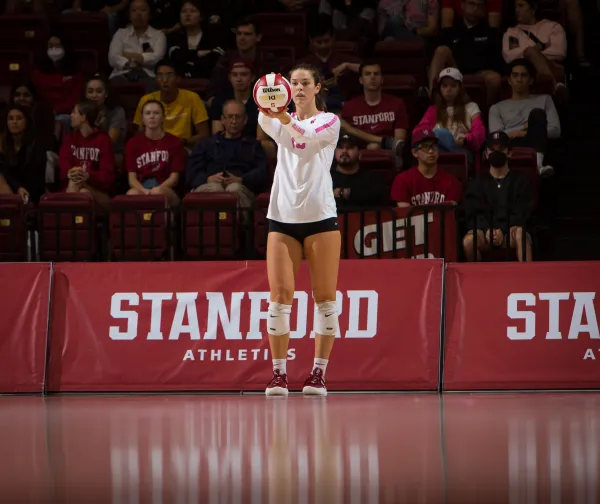 Elia Rubin stands with ball preparing to serve from the back of the court