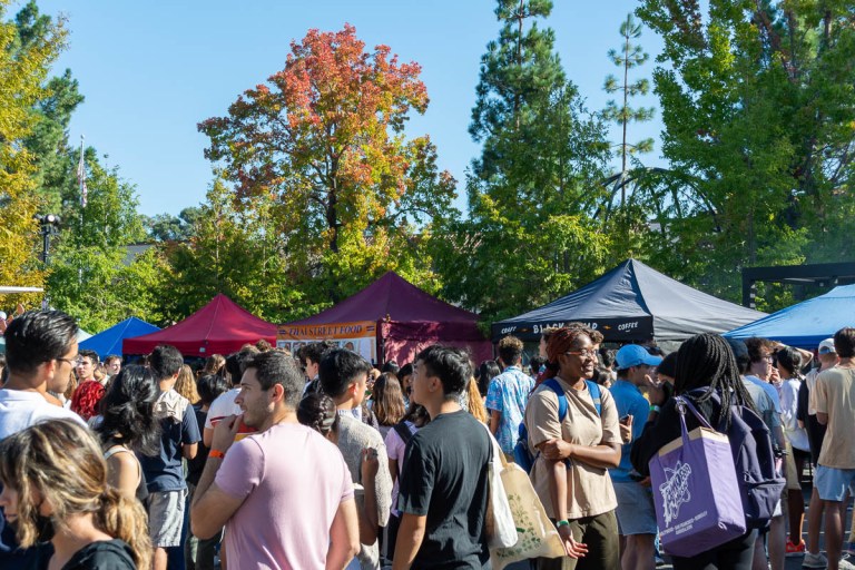 many students crowd around five colored tents