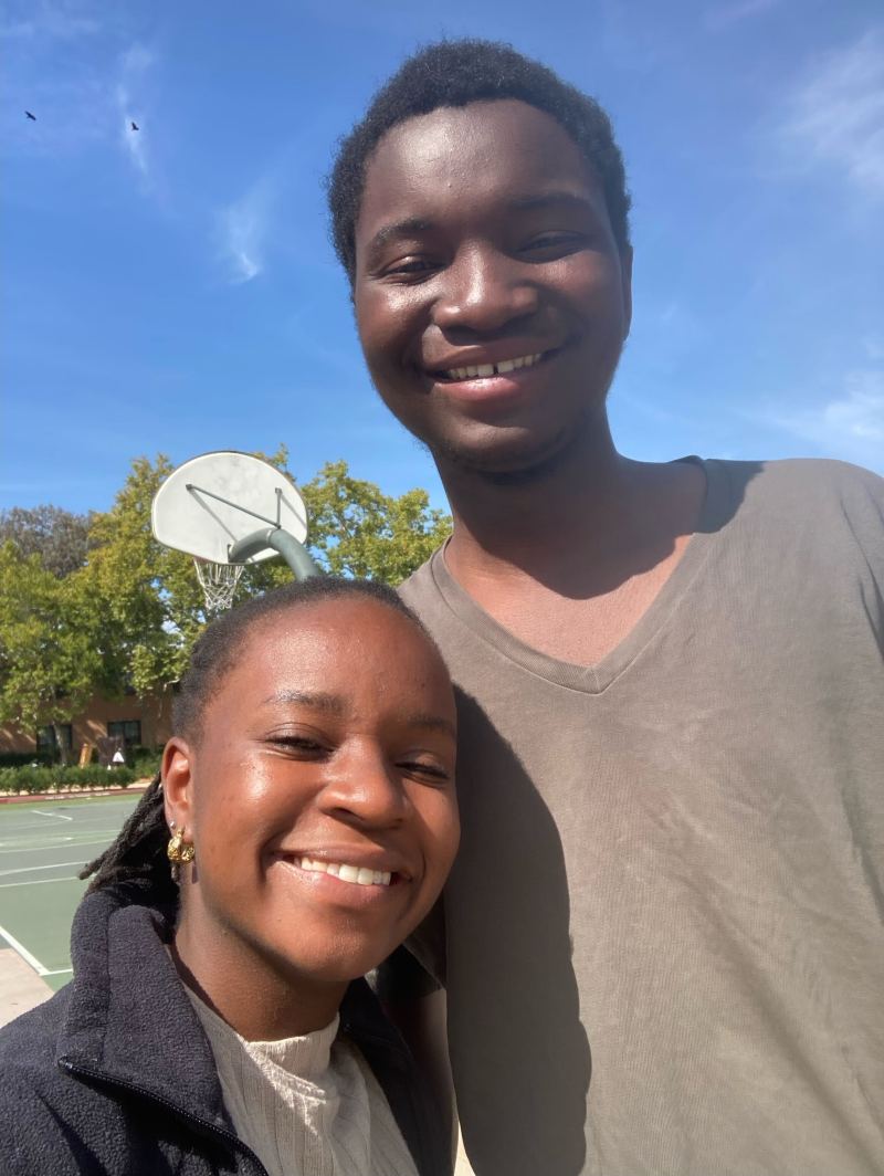 A selfie of Nyandoro and Mphamba with a basketball hoop in the background