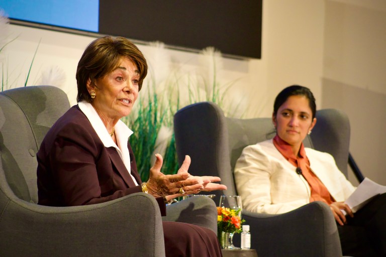 Anna Eshoo sits in a chair next to a moderator on the stage