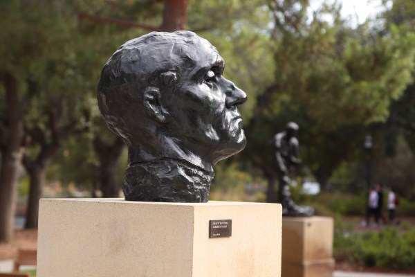 The sideview of a bronze head sculpted by Auguste Rodin.