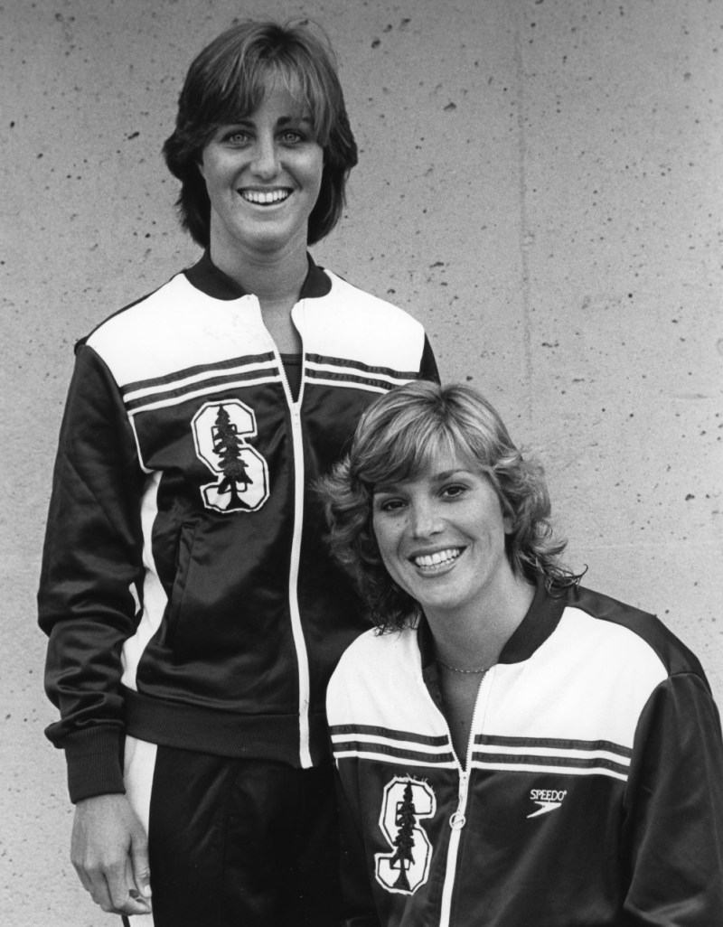 Swimmers Jenny Rapp (standing) and Marybeth Linzmeier Dorst (foreground) pose for a photo in their Stanford warmup jackets.