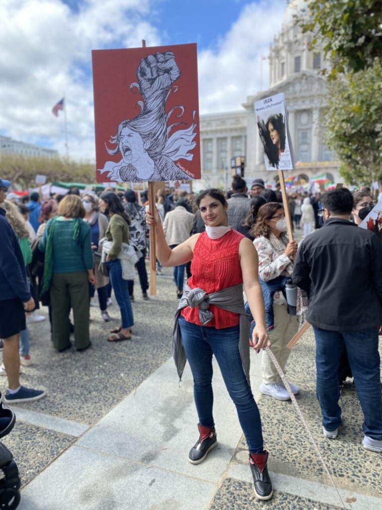 Arghavan Salles holds a sign at a protest.