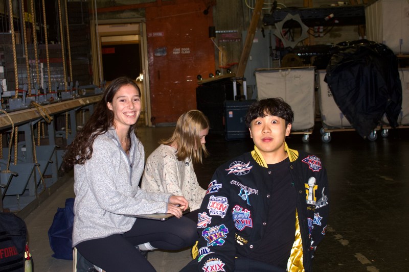 Three Gaieties cast members during rehearsal break in the theater. Two cast members stare into the camera in surprise