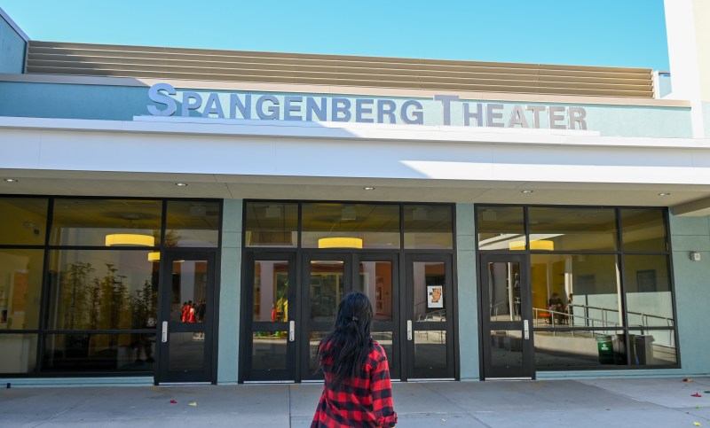 Anita Su's back is shown as she stands in front of a theater. 