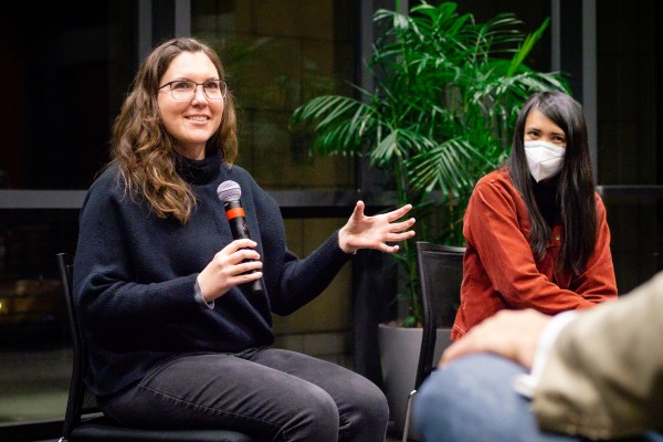 Two ladies on a stage during a Q&A session. One of them is in the middle of answering a question.