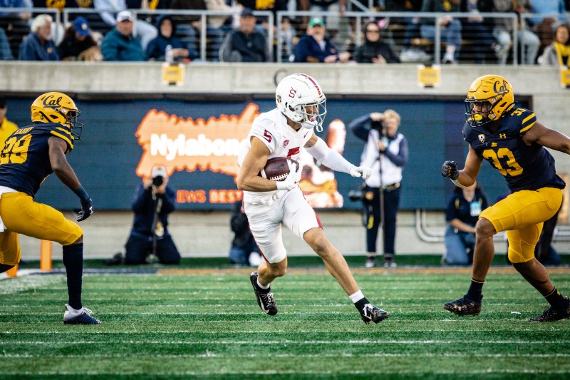 A football player runs with the ball in his right hand