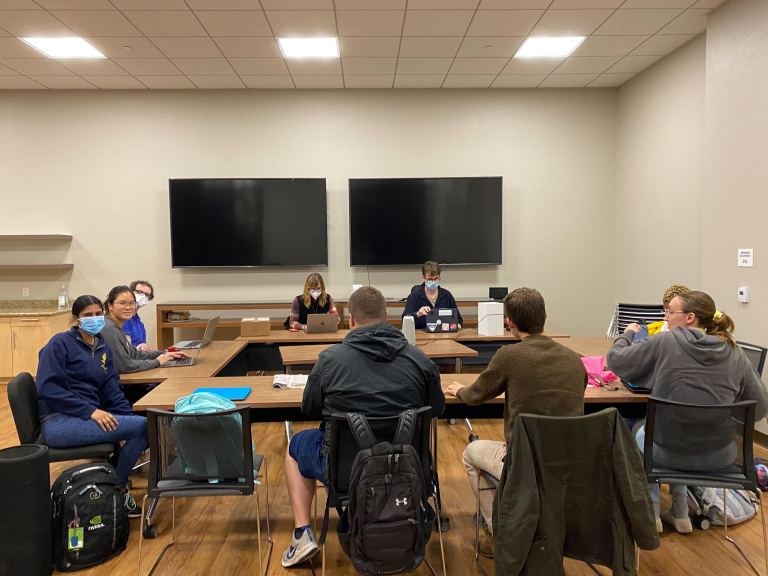 students sitting around table for Graduate Student council meeting on 11/9