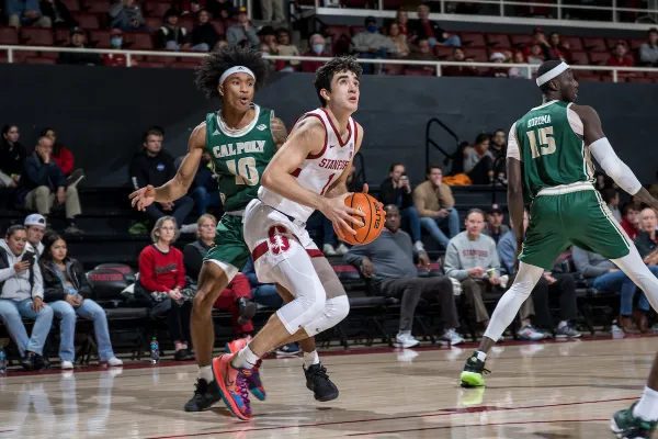 A basketball player looks up at the basket as he prepares to shoot