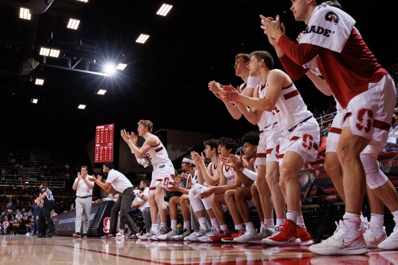 Basketball players on the bench stand up and clap