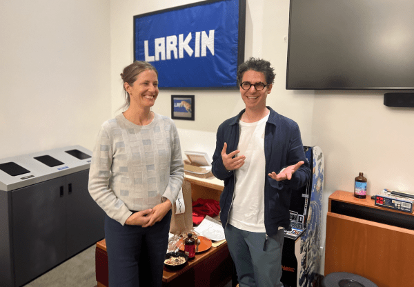 Two people stand in front of a banner that reads "LARKIN"