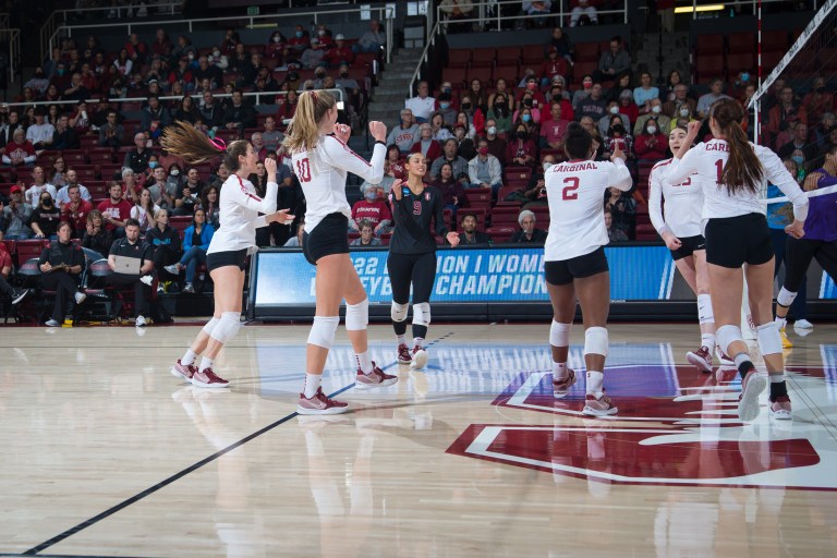 Players celebrate between points during a volleyball game.