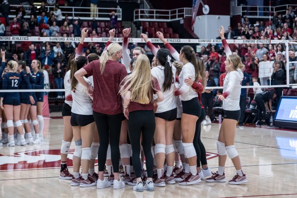 A volleyball team huddles together