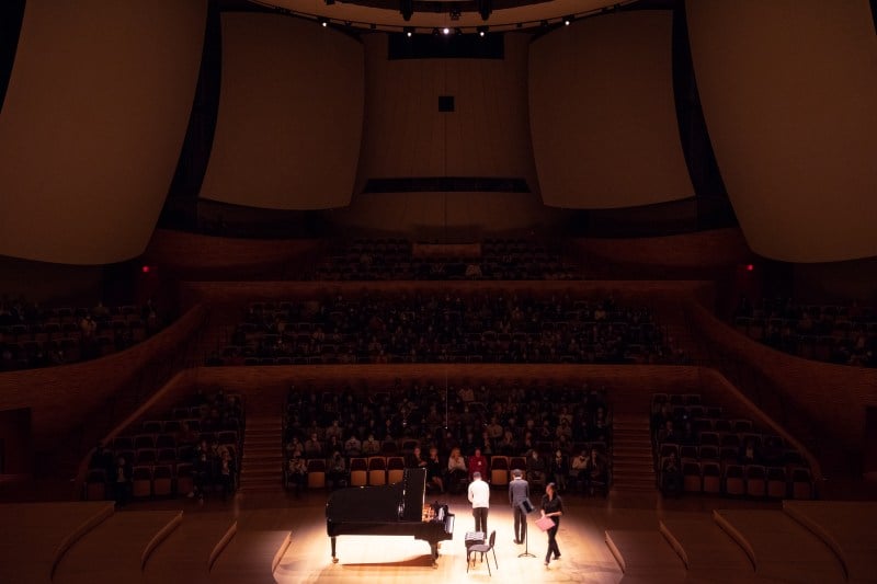 After their performance, Goosby and Wang take a bow, a spotlight shining down on them in center stage. 