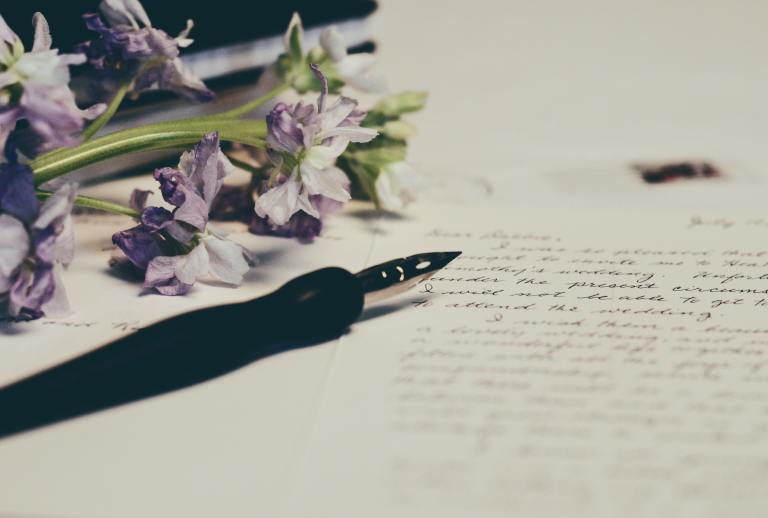 A fountain pen and flowers on paper.