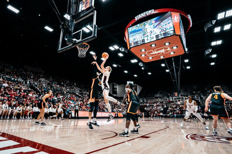 A basketball player rises up to finish