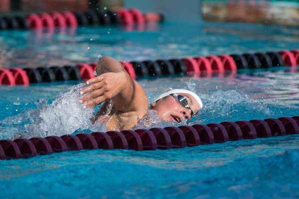 A female swimmer emerges from the water during freestyle stroke