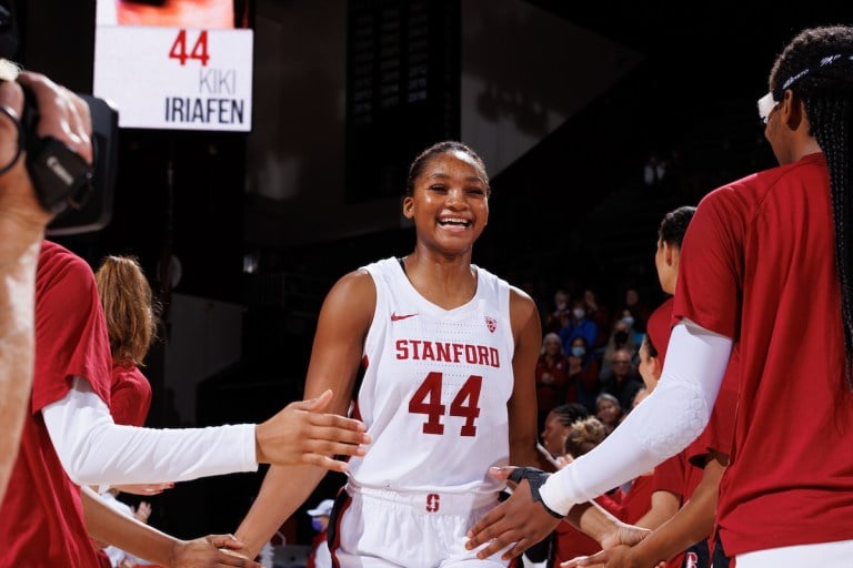 A basketball player high fivers her teammates with both hands