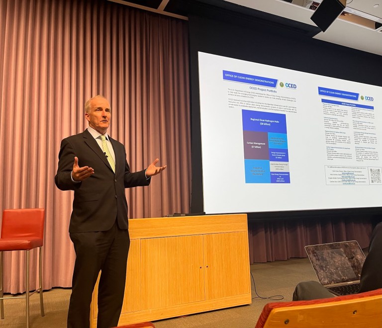 U.S. Office of Clean Energy Demonstrations Director David Crane stands in front of presentation