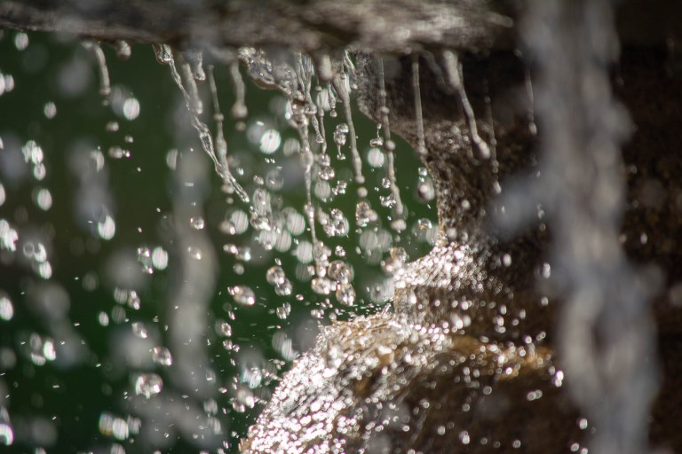 A close up shot of water against a green background.