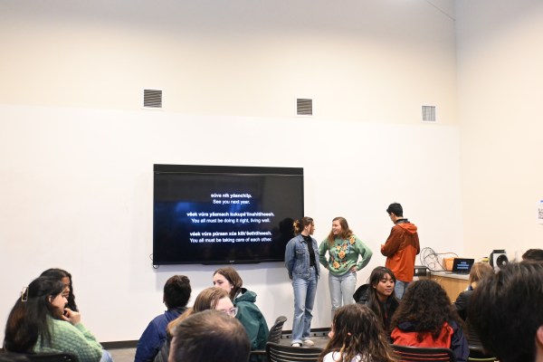 People looking at a screen in a white room.