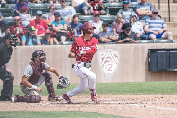 Baseball players on pitch as stanford batter hits a ball