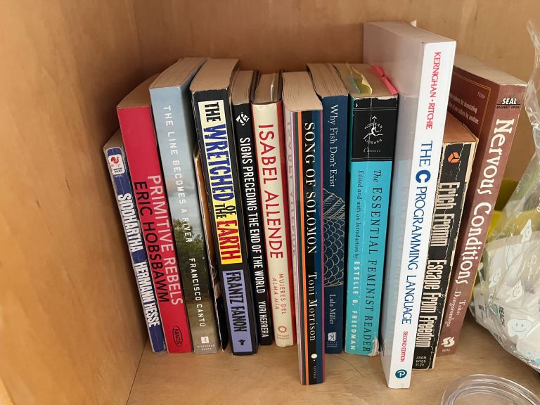 A collection of worn books nestled within a bookshelf.