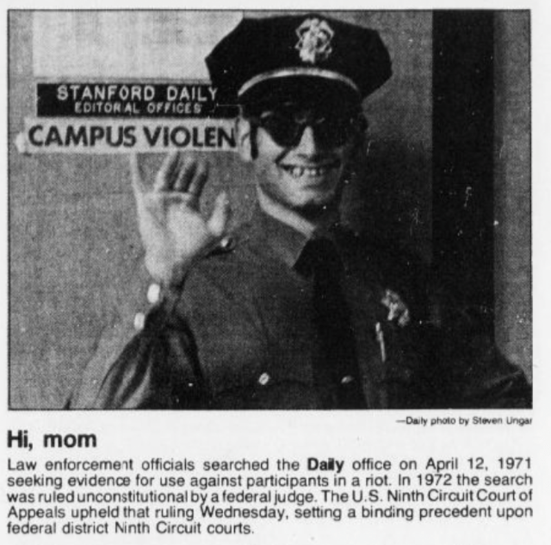 Photo of law enforcement official waving in front of The Stanford Daily house.