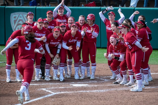 Players celebrate in a semi-circle during a softball game.