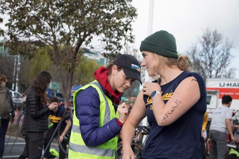 A triathlete receives their race number prior to competing.