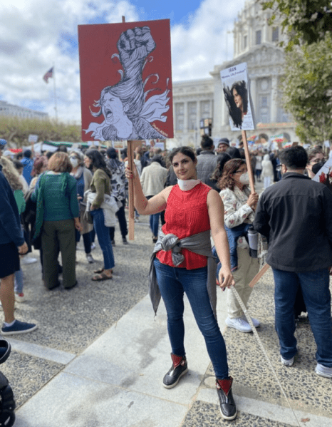 Arghavan Salles holds a sign at a protest.