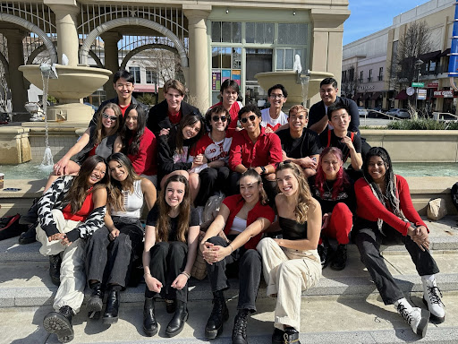 The members of Mixed Company are sitting outside and posing for a photo.