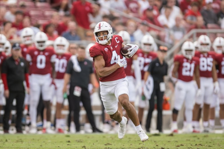 Michael Wilson runs with the football tucked under his arm during a game.