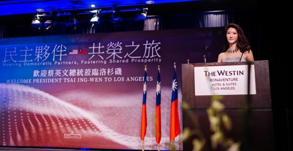 Tiffany Chang stands at a podium in front of a screen and delivers remarks at President Tsai's banquet.